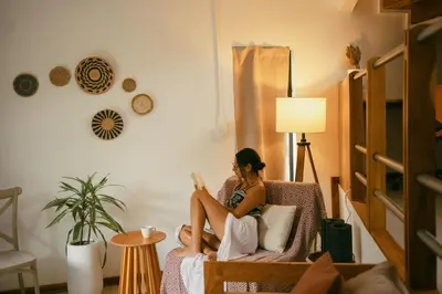 a woman sitting in a chair reading a book at Mar Botánico - Avellanas Beach Hotel in Playa Avellana