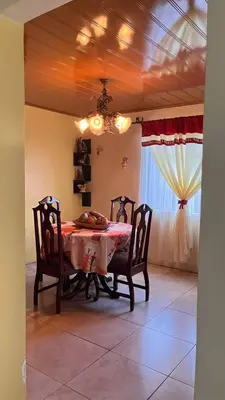a dining room with a table and chairs and a window at Casa morfo in Bijagua