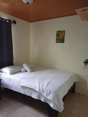 a bed in a bedroom with a picture on the wall at Casa morfo in Bijagua