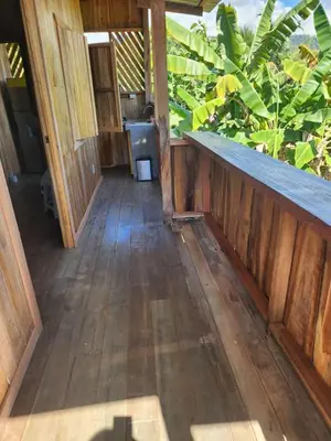 an empty room with a wooden floor and plants at Paso-lapas in Matapalo