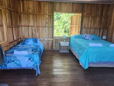two beds in a room with a window at Paso-lapas in Matapalo