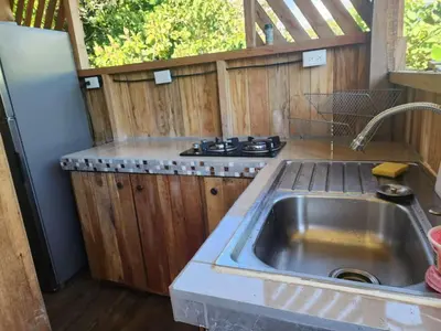 a kitchen with a sink and a refrigerator at Paso-lapas in Matapalo