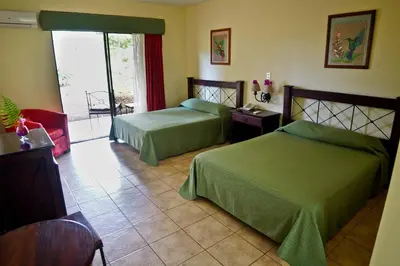 a hotel room with two beds and a balcony at Natural Lodge Caño Negro in Caño Negro