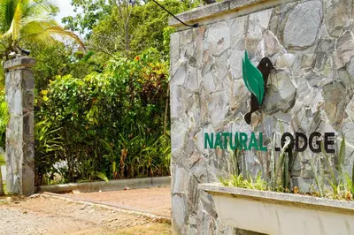 a sign on the side of a stone wall at Natural Lodge Caño Negro in Caño Negro