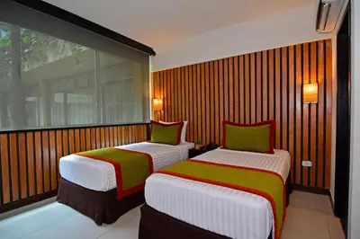 two beds in a room with a window at Auténtico Hotel in San José