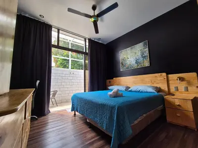 a bedroom with a blue bed with a teddy bear on it at Sabana Studios in San José