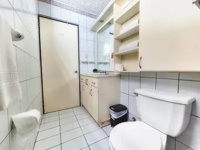 a white bathroom with a toilet and a sink at Sabana Studios in San José