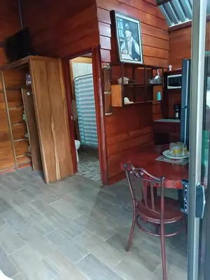 a kitchen with a table and a chair in a room at Cabaña Rincón de Curubandé in Liberia