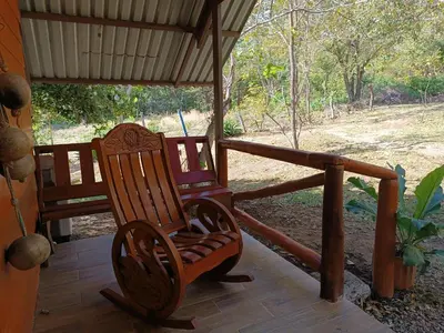 two rocking chairs on a porch of a house at Cabaña Rincón de Curubandé in Liberia