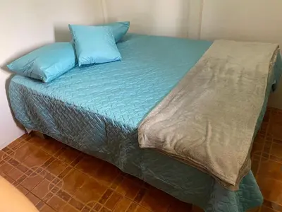a bed with two blue pillows on top of it at Casas La Chirincoca in San Isidro