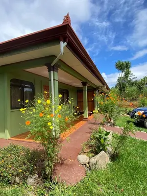 a green house with flowers in front of it at Casas La Chirincoca in San Isidro