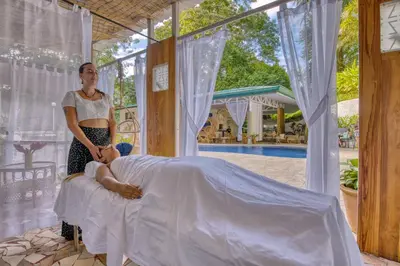a woman standing next to a man sitting on a bed at ECOTICA Boutique Hotel & Spa in Manuel Antonio