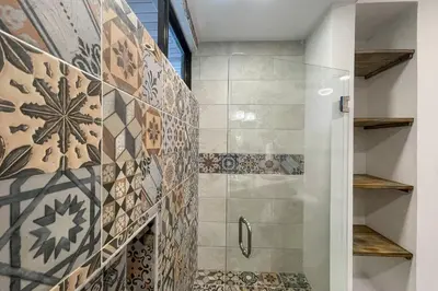a bathroom with a shower with a glass door at ECOTICA Boutique Hotel & Spa in Manuel Antonio
