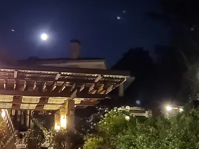 a view of a house at night with the moon at Finca Paraiso Mountain Retreat near San Jose Airport in Birrí