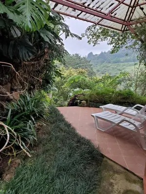 a couple of white chairs sitting on a patio at Finca Paraiso Mountain Retreat near San Jose Airport in Birrí