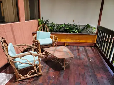 two wicker chairs and a table on a porch at Finca Paraiso Mountain Retreat near San Jose Airport in Birrí