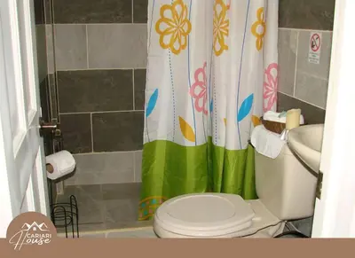a bathroom with a toilet and a shower curtain at Full house, 11BR, 12BA, 10 min from SJO Airport in Heredia