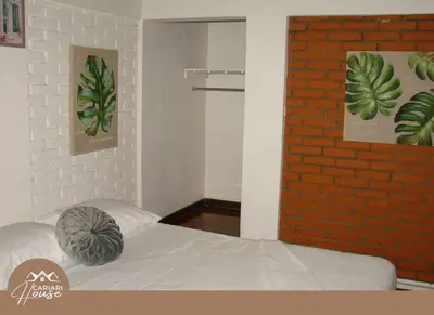 a bedroom with a bed and a brick wall at Full house, 11BR, 12BA, 10 min from SJO Airport in Heredia