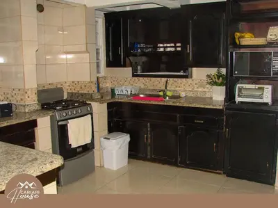 a kitchen with black cabinets and a stove at Full house, 11BR, 12BA, 10 min from SJO Airport in Heredia