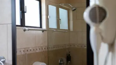 a bathroom with a shower with a mirror and a sink at MonteMar Beach Condo At Playa hermosa in Sardinal
