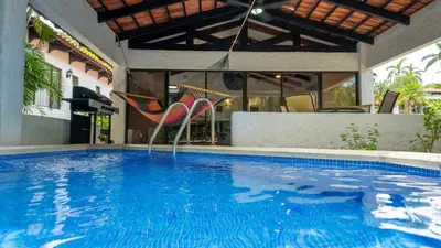 a swimming pool with a hammock in a house at MonteMar Beach Condo At Playa hermosa in Sardinal