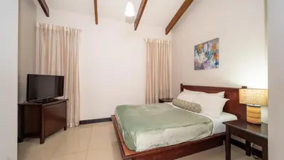 a bedroom with a bed and a flat screen tv at MonteMar Beach Condo At Playa hermosa in Sardinal