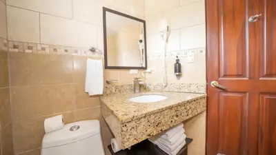 a bathroom with a sink and a toilet and a mirror at MonteMar Beach Condo At Playa hermosa in Sardinal