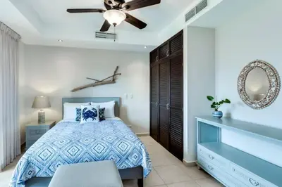 a bedroom with a bed and a ceiling fan at Rooftop balcony oceanfront PH condo with King beds in Jacó