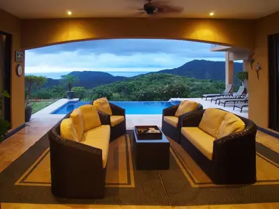a living room with two chairs and a pool at Casa Sol Azul - remarkable, ocean view 4 BR House in Potrero in Potrero