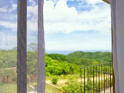 a window with a view of the mountains at Casa Sol Azul - remarkable, ocean view 4 BR House in Potrero in Potrero