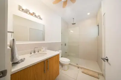 a bathroom with a sink and a toilet and a mirror at Condo Casa Blanca 6 - modern 2BR,2BA near to Beach & Town in Potrero