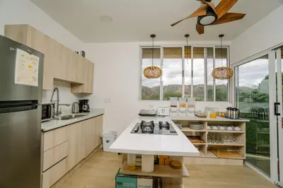 a kitchen with white counters and a large window at Glamping Tortuga Verde in Ocotal