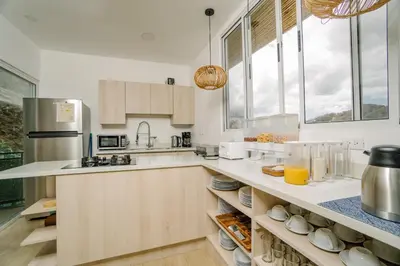 a kitchen with white counter tops and windows at Glamping Tortuga Verde in Ocotal