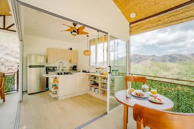 a kitchen and dining room with a table and chairs at Glamping Tortuga Verde in Ocotal