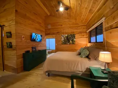 a bedroom with a bed in a log cabin at Cabañas Emerald Forest in Concepción
