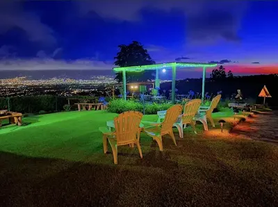 a group of chairs and a table on a lawn at night at Cabañas Emerald Forest in Concepción