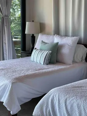 a bedroom with a white bed with pillows and a window at Villa Del Mar 2 Spectacular ocean view! in Dominical