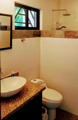 a bathroom with a sink and a toilet at VILLA SIMONE ARENAL French Ecolodge in Tilarán