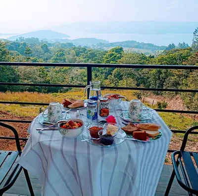a table with food on it with a view at VILLA SIMONE ARENAL French Ecolodge in Tilarán