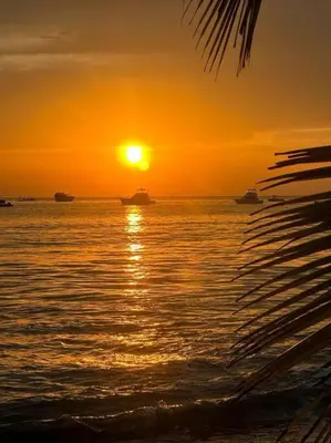 a sunset over the ocean with boats in the water at Casa Bella in Jacó
