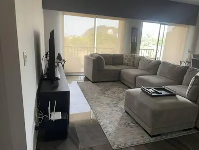 a living room with a couch and a tv at Casa Bella in Jacó