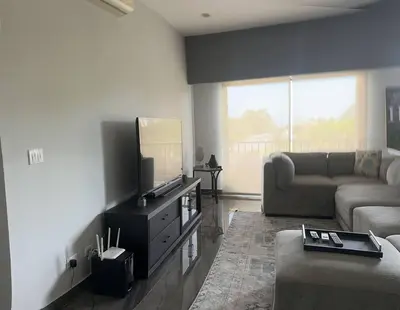 a living room with a couch and a flat screen tv at Casa Bella in Jacó