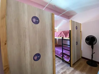 a room with a wooden door with two bunk beds at Casa Pandora Hostel Women Only in San José