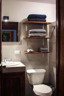 a bathroom with a toilet and a sink and towels at Chocolate in Tamarindo