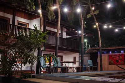 a patio with a table and chairs at night at Chocolate in Tamarindo