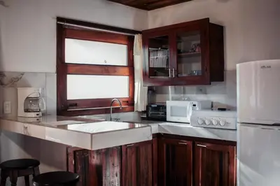 a kitchen with a sink and a white refrigerator at Chocolate in Tamarindo