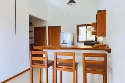 a kitchen with a counter with chairs and a sink at Casa Kabuae in Portalón