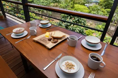 a wooden table with food and coffee on a balcony at Casa Kabuae in Portalón