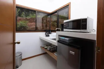 a small kitchen with a microwave and a window at Casa Kabuae in Portalón