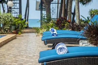 a row of blue chairs with a stuffed animal on them at Hotel El Velero in Playa Hermosa